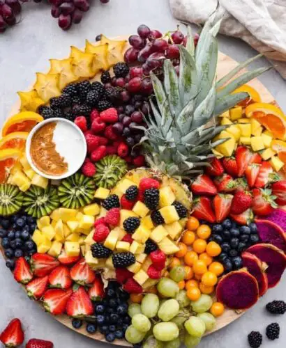 Colorful fruit charcuterie board with pineapple.